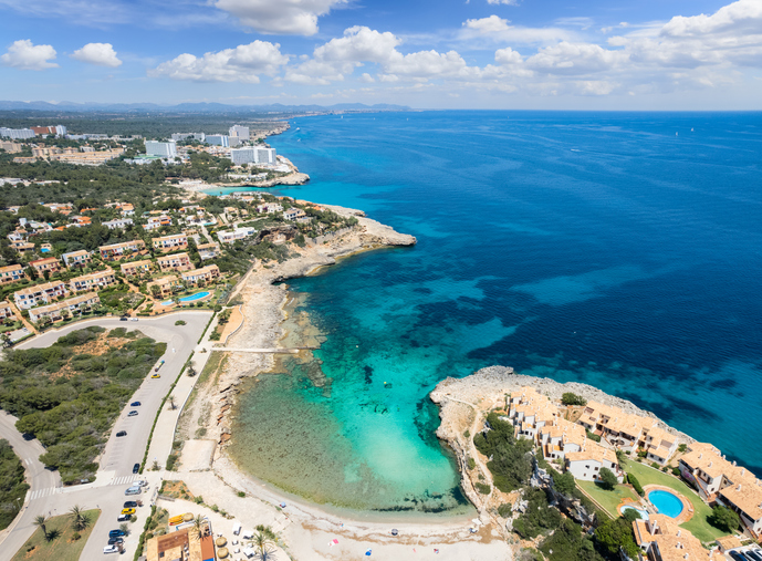 Weiter Luftblick über Cala Murada mit Badebucht, Ferienhäusern und tiefblauem Mittelmeer