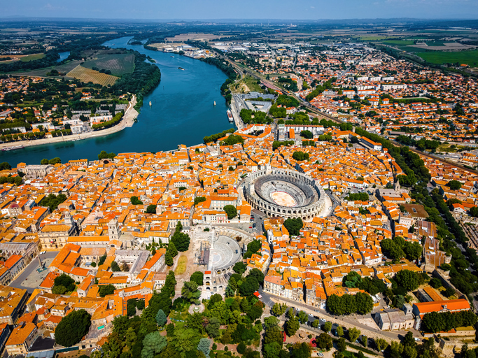 Luftbild von Arles mit dicht bebauter Altstadt, Amphitheater und Flusslauf