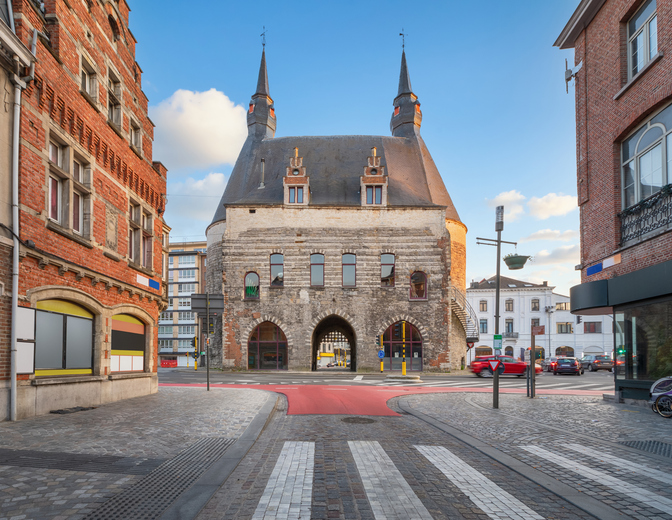 Mittelalterliche Brusselpoort in Mechelen mit zwei runden Türmen, Spitzdächern und mehreren Torbögen.