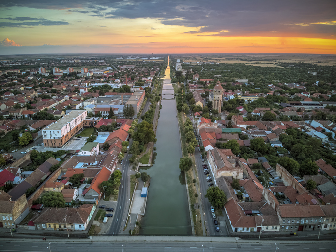 Luftaufnahme des Bega-Kanals bei Sonnenuntergang mit Stadtansicht