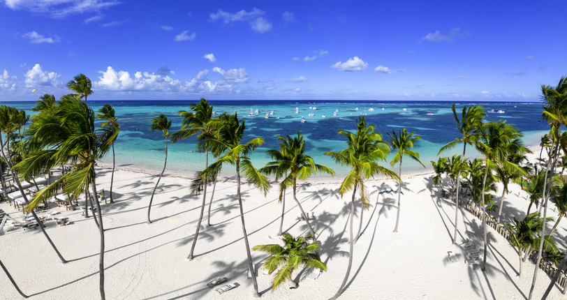 Weißer Sandstrand mit Palmen und türkisfarbenem Meer in Punta Cana