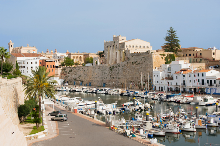 Blick auf den Hafen von Ciutadella mit Booten, Uferpromenade und historischer Bebauung