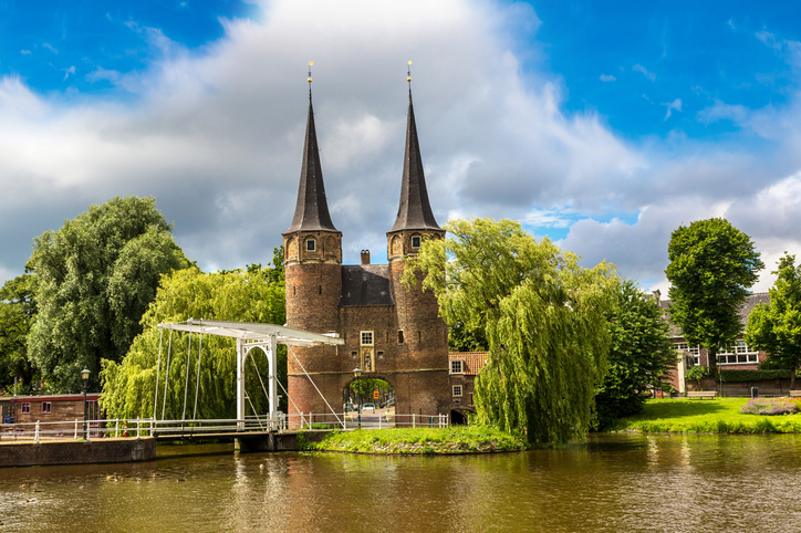 Das historische Stadttor Oostpoort mit zwei Türmen steht an einem Kanal in Delft.