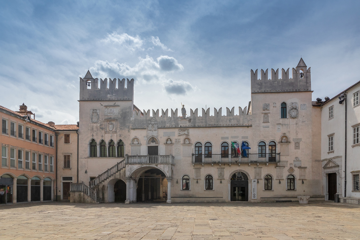 Heller historischer Palast mit Zinnen und Arkaden auf dem Hauptplatz von Koper