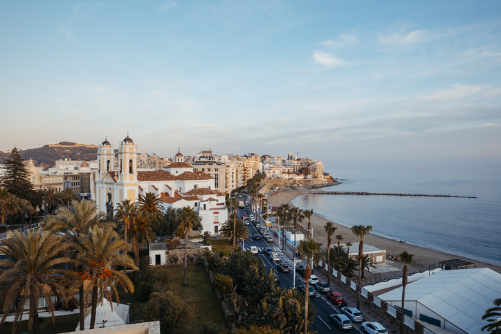 Blick auf Kirche, Palmen und Uferstraße an der Küste von Ceuta