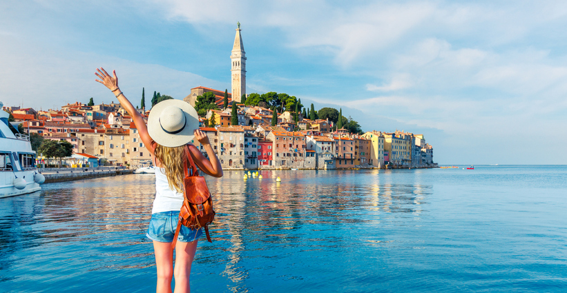 Küstenansicht von Rovinj mit Altstadt, Kirchturm und ruhigem Wasser im Vordergrund