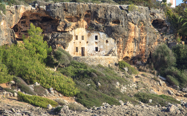 Altes Steinhaus in einer natürlichen Felshöhle nahe der Küste von Cala Murada