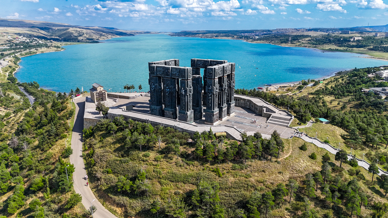 Luftaufnahme der Chronik von Georgien in Tiflis auf einem Hügel oberhalb des Tiflis-Sees mit weiter Landschaft und blauem Wasser.