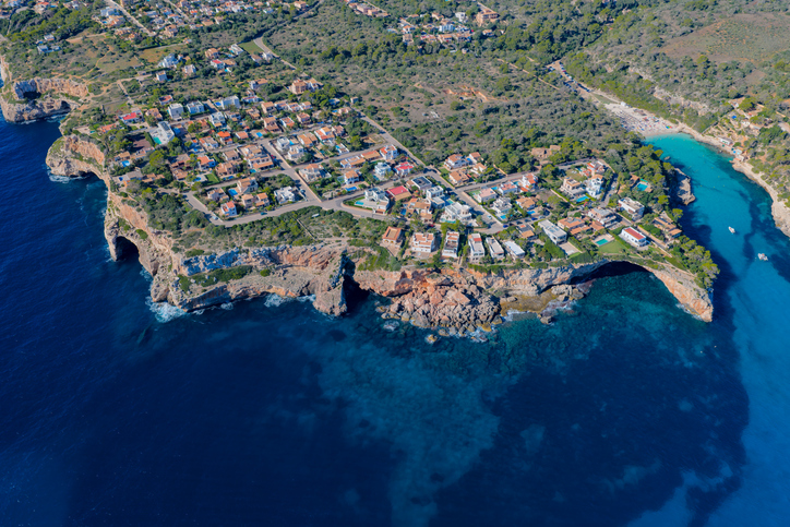 Luftaufnahme der felsigen Küste und Wohnsiedlung rund um die Cala Santanyí auf Mallorca
