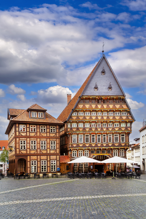Knochenhauer-Amtshaus am Marktplatz von Hildesheim mit reich verzierter Fachwerkfassade, steilem Giebeldach und Außengastronomie.
