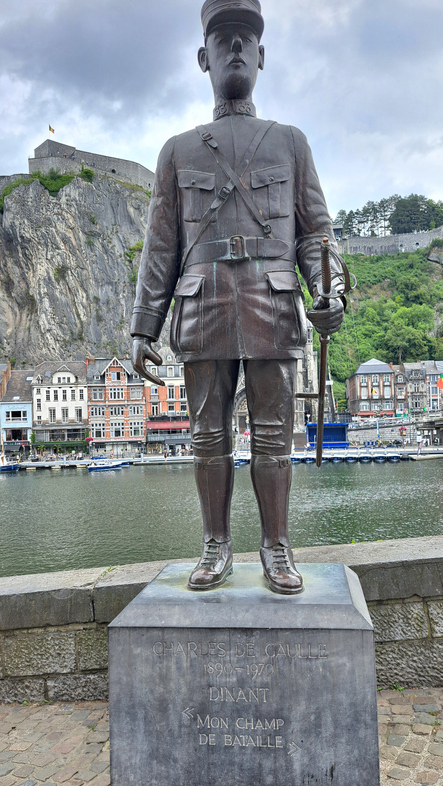 Bronzestatue eines Soldaten am Ufer der Maas in Dinant vor Felsen, Festung und Altstadt.