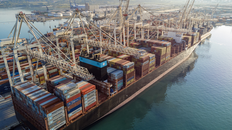 Großes Containerschiff an Kränen im Hafen von Koper