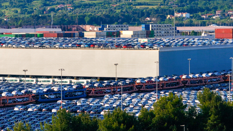 Große Fläche mit zahlreichen Autos und Logistikanlagen im Hafen von Koper