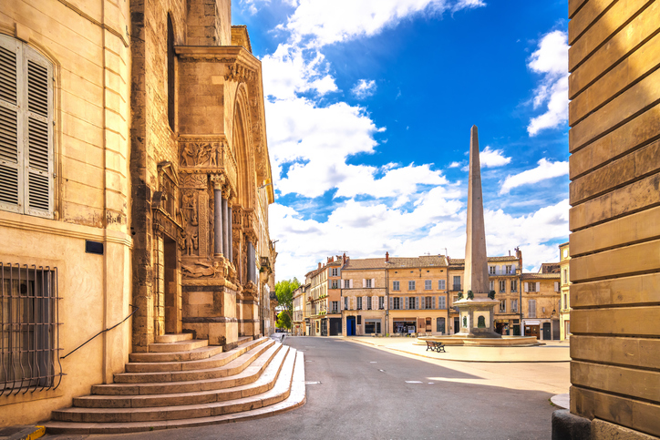Sonniger Platz in Arles mit Obelisk, Kirche und historischen Gebäuden