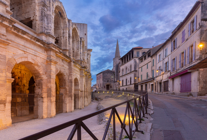 Schmale Straße entlang des römischen Amphitheaters in Arles bei Dämmerung