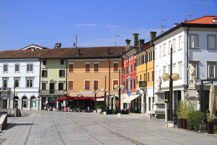 Historische Häuser mit bunten Fassaden und Straßencafés an der Piazza Grande in Palmanova