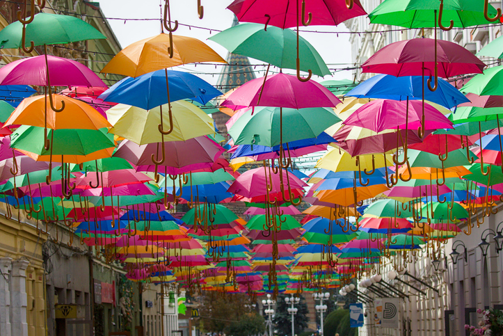 Viele farbenfrohe Regenschirme hängen als Dekoration über einer Straße in Timișoara