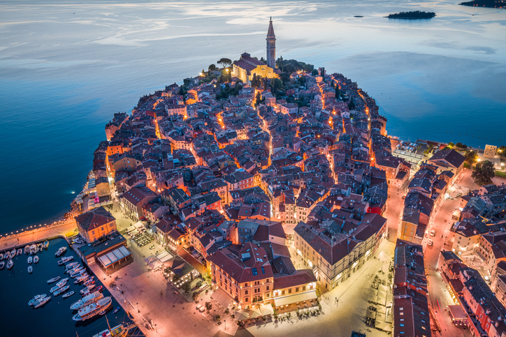 Nächtliches Luftbild von Rovinj mit beleuchteter Altstadt und Kirchturm auf der Halbinsel