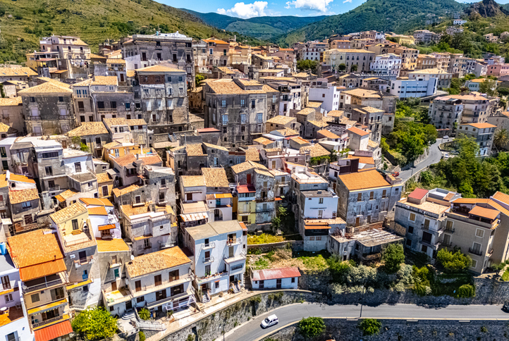 Luftaufnahme der dicht bebauten Altstadt von Cosenza mit alten Häusern und grünen Bergen