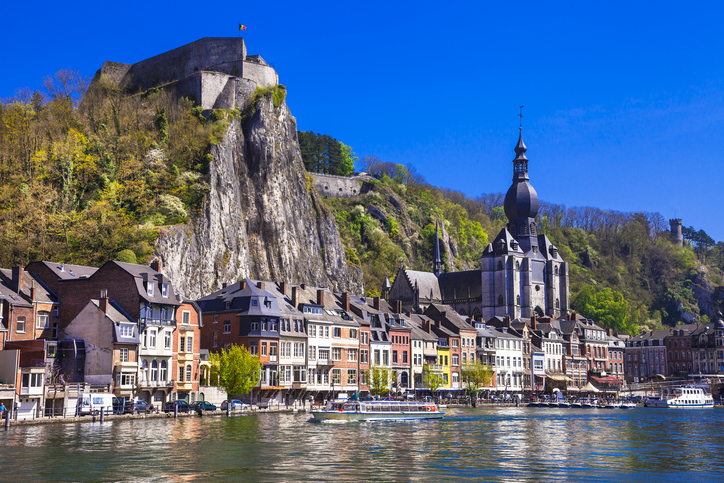 Blick auf die Altstadt von Dinant mit Kirche, Zitadelle auf dem Felsen und Spiegelungen in der Maas.