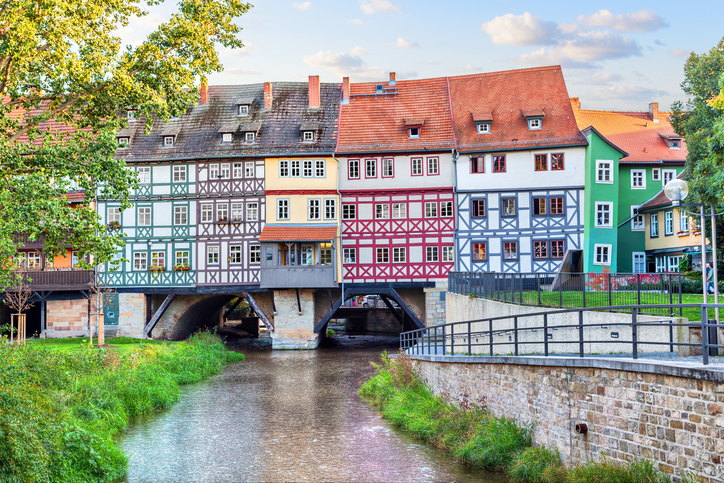 Krämerbrücke in Erfurt mit bunten Fachwerkhäusern über dem Fluss und Uferwegen an beiden Seiten.
