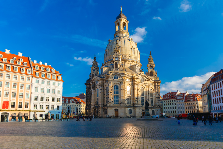 Dresdner Frauenkirche am Neumarkt mit monumentaler Kuppel, barocker Fassade und historischen Gebäuden unter blauem Himmel.