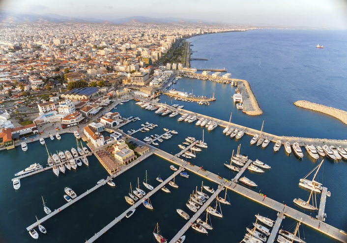 Luftaufnahme der Marina von Limassol mit zahlreichen Segelbooten und Yachten, Hafenbecken, Molen und weitläufiger Küstenstadt.
