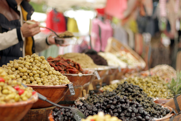 Marktstand mit verschiedenen Olivensorten und mediterranen Produkten in Arles