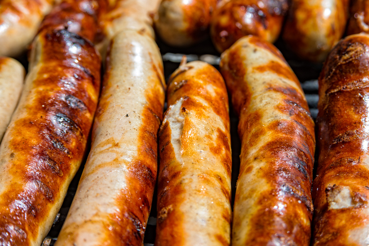 Mehrere Thüringer Bratwürste auf dem Grill mit goldbraun gerösteter Oberfläche und dunklen Grillstellen.
