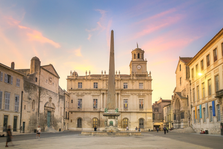 Platz mit Obelisk und historischem Rathaus in Arles bei Abendlicht