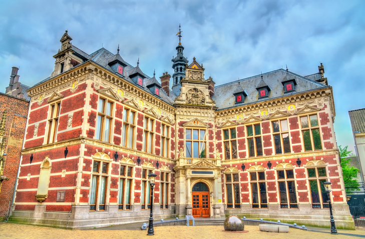 Historisches Academiegebouw in Utrecht mit reich verzierter rot-weißer Fassade, großen Fenstern und repräsentativem Eingangsportal.